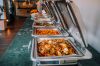 An elegant buffet setup featuring various delicious dishes in stainless steel chafing dishes, perfect for events.