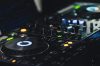 A detailed shot of professional DJ equipment featuring knobs and LED lights, perfect for music events.
